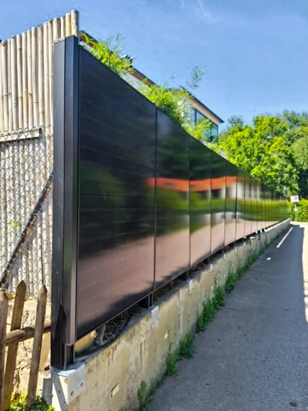 Solarzaun entlang eines Gehwegs