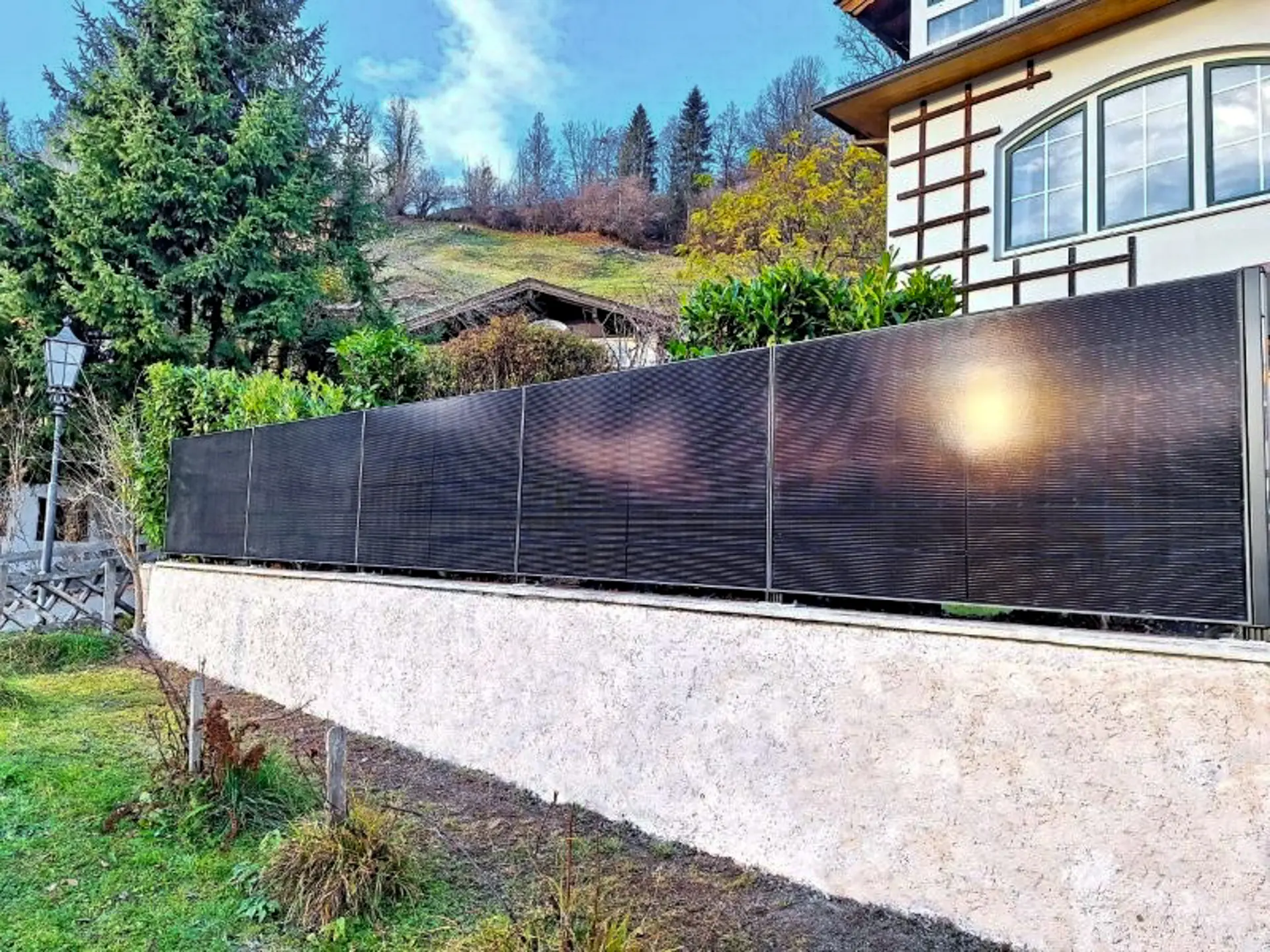 Solarzaun mit bifazialen Modulen auf einer Gartenmauer